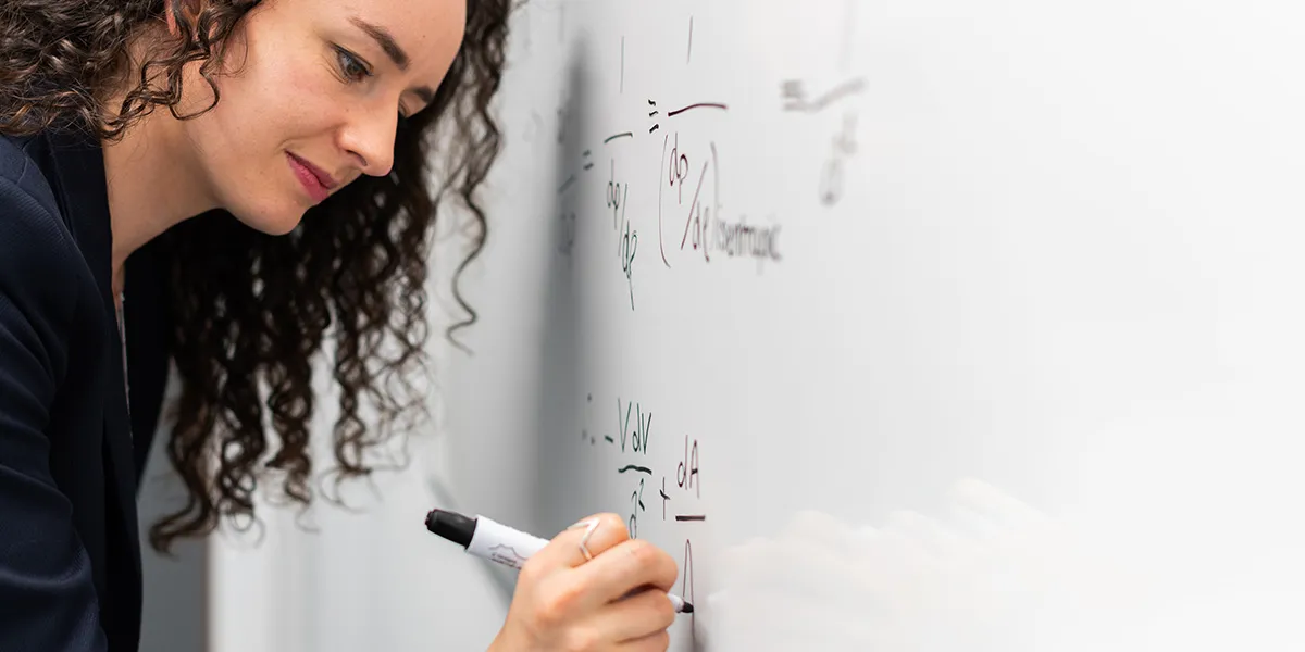 woman writing formula on whiteboard