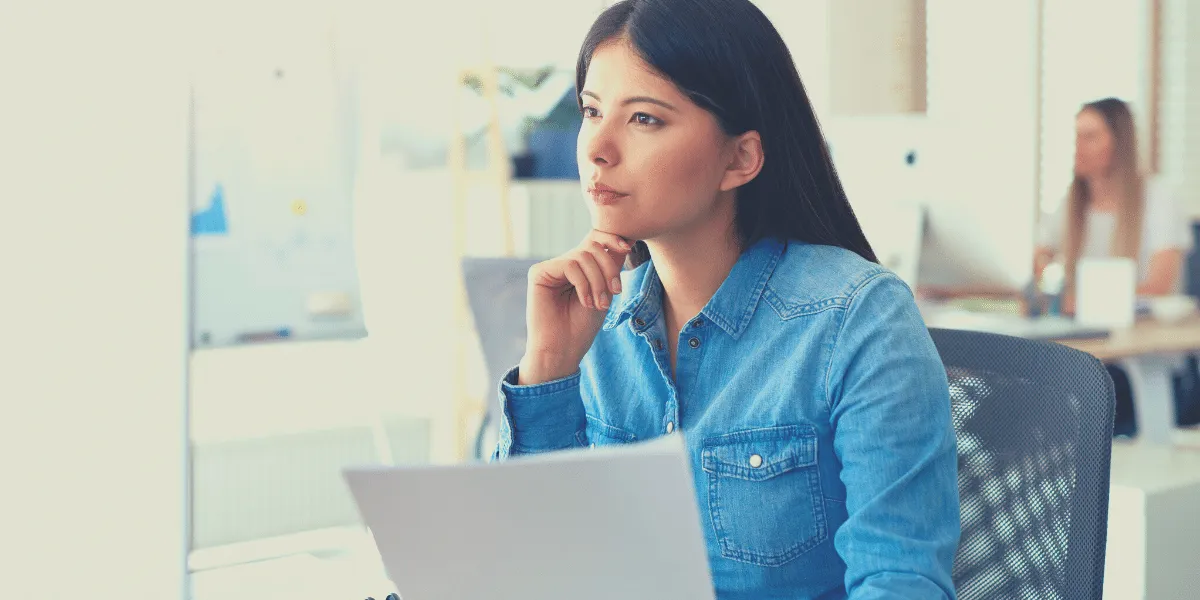 Woman at desk thinking about HR trends for 2023